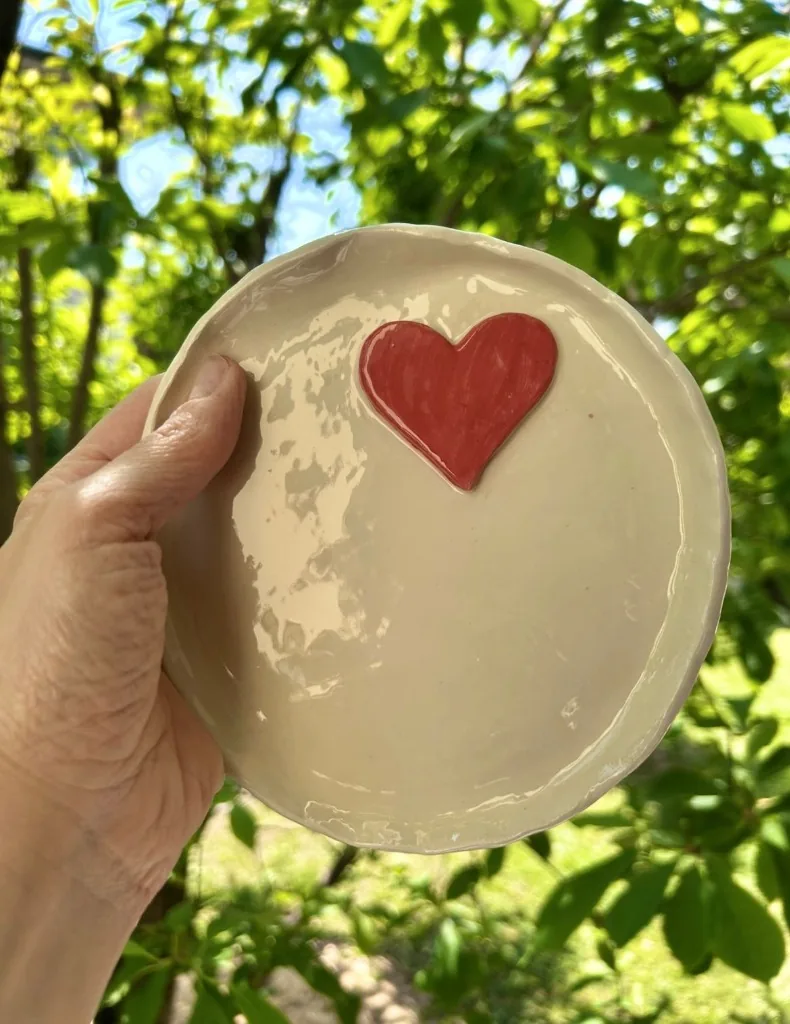 Piattino in ceramica bianca con un cuore rosso a rilievo nel centro